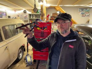 Portrettfoto av Ståle Eskeland føre bilen sin på verkstaden. Foto: Privat